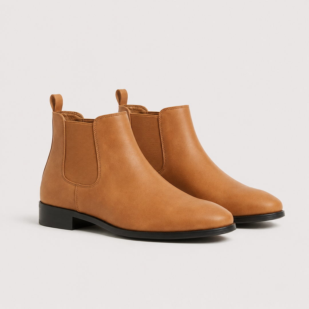 A pair of tan leather Chelsea boots with black soles, displayed on a light gray background.