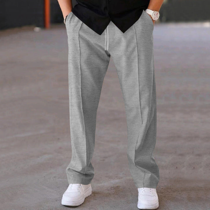 Man relaxing in grey loungewear sweatpants, emphasizing ultimate comfort &amp; casual style.